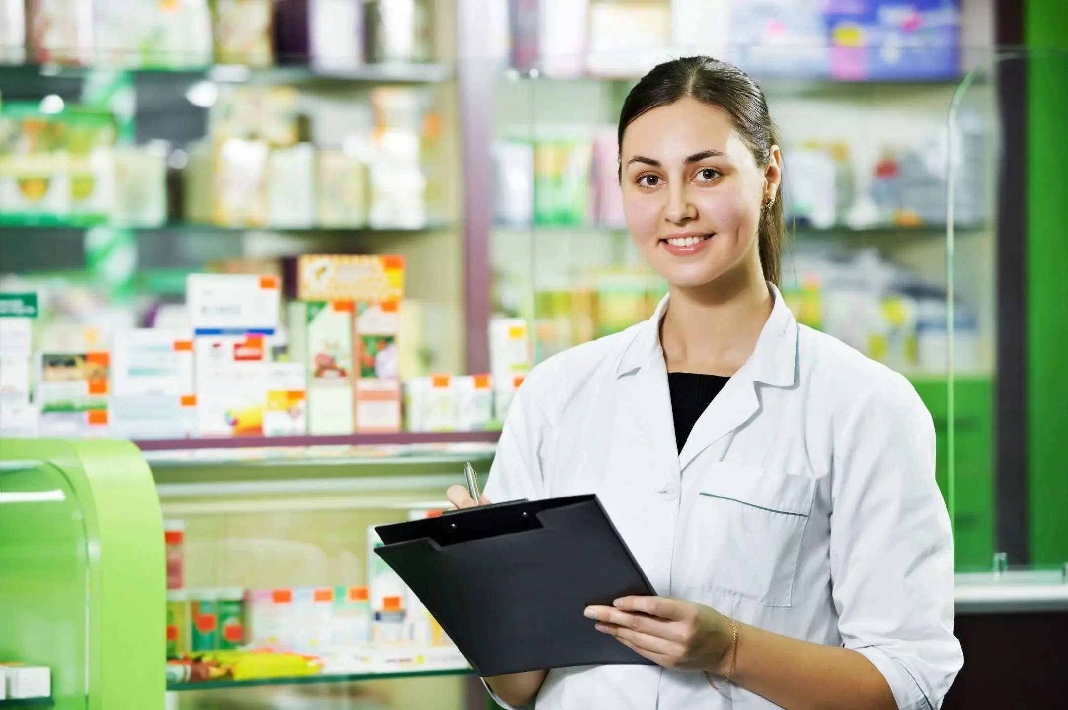 A woman holding a clipboard in front of shelves.