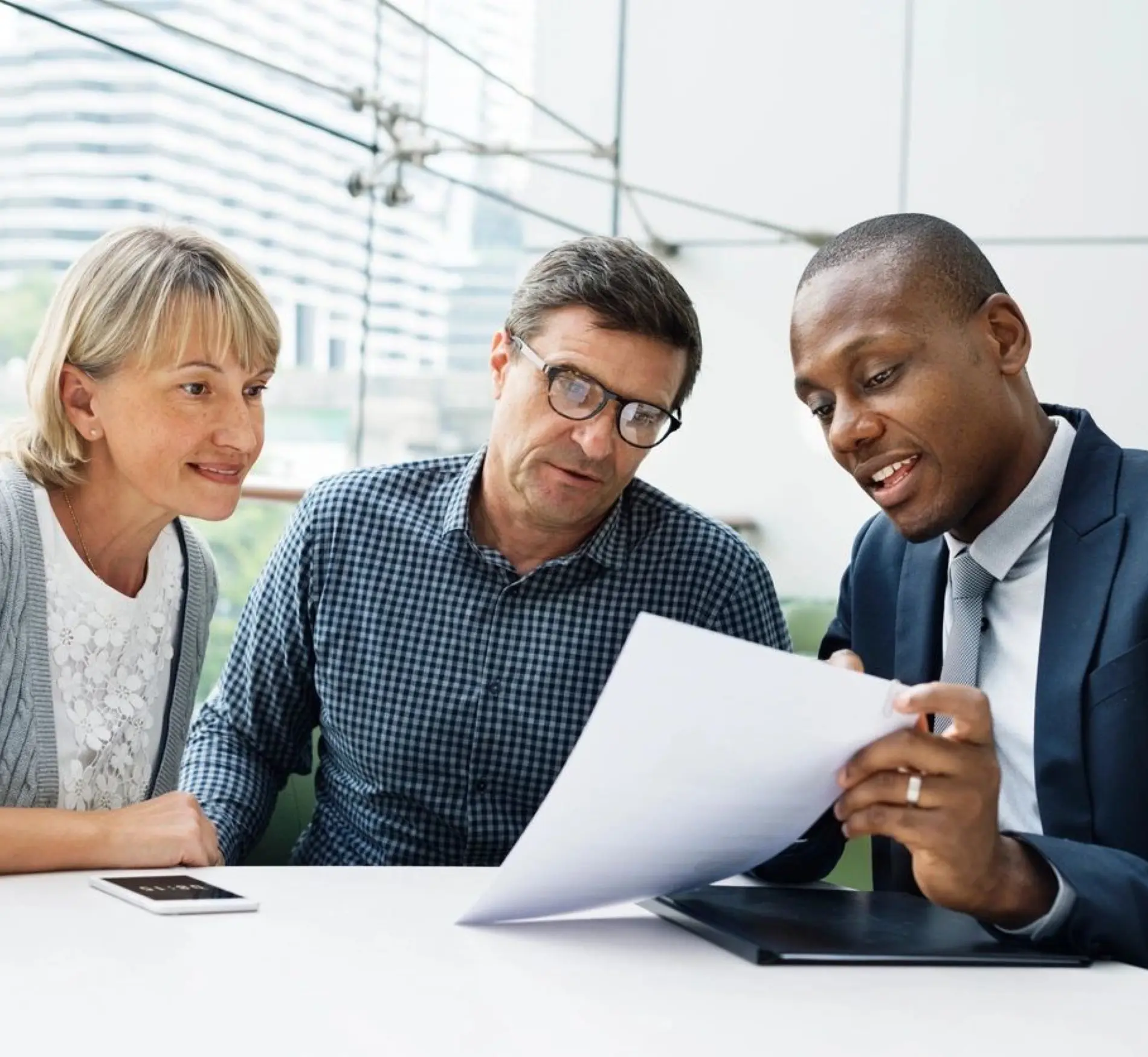 A man and two women looking at papers.