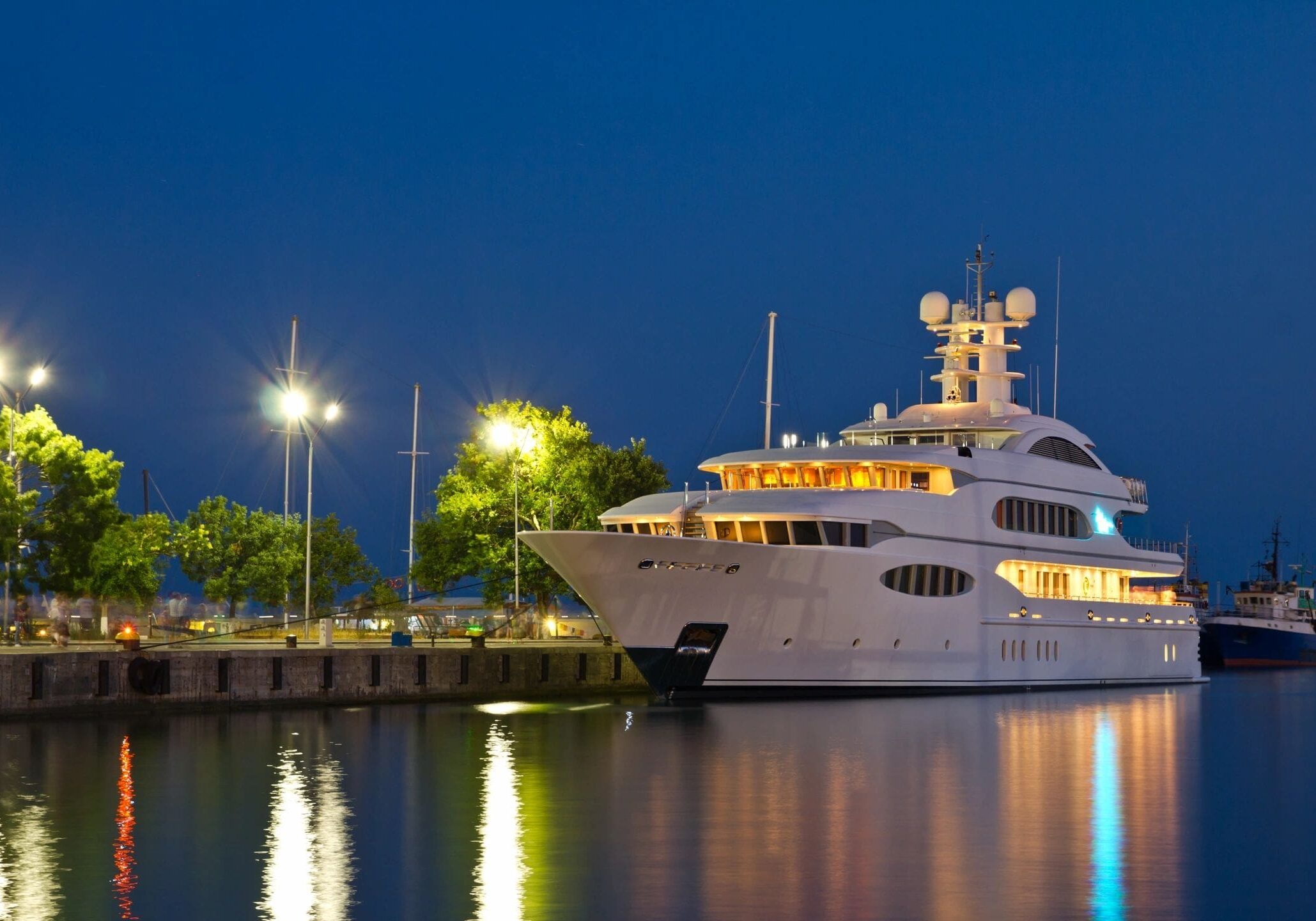 A large white boat docked at the dock.