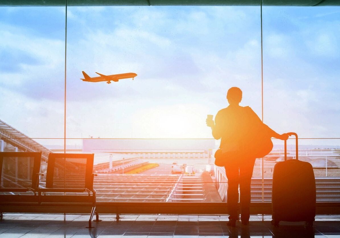 A person standing in front of an airport window.