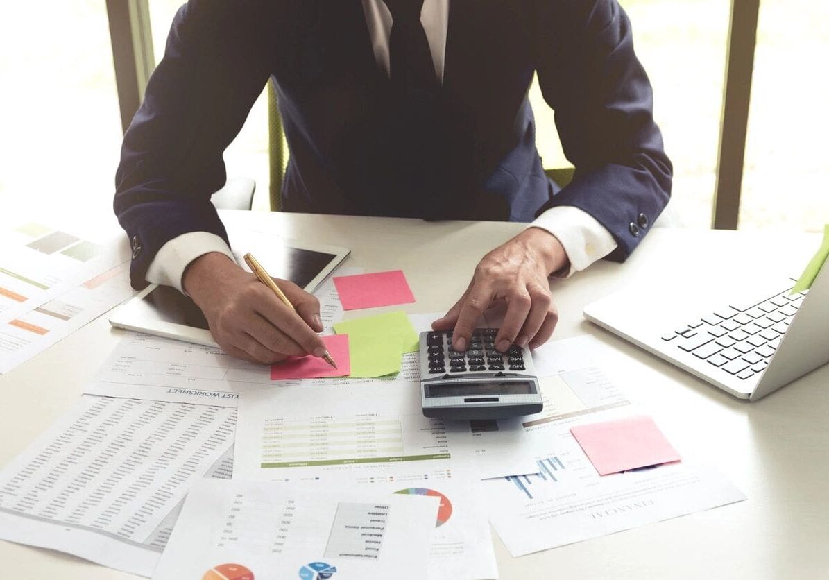 A man in a suit and tie at a table with papers.